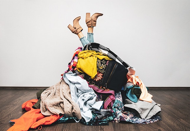 A pile of clothes and shoes on the floor